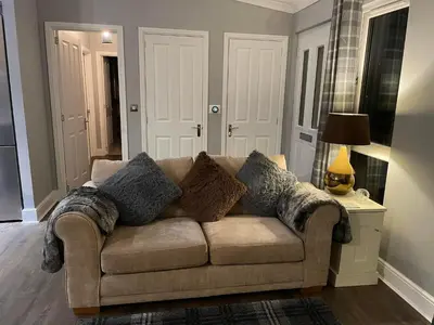 a couch with pillows on it in a living room at Riverbank Lodge in Dollar