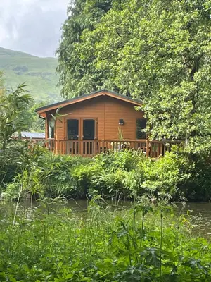 a house on the side of a river at Riverbank Lodge in Dollar