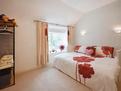 a bedroom with a bed with flowers on it at Nether Auchlinsky Cottage in Glendevon