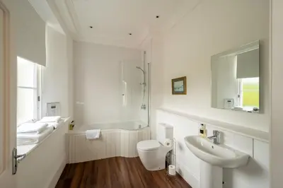 a white bathroom with a toilet and a sink at Alexander House 24 - Self Catering in Auchterarder