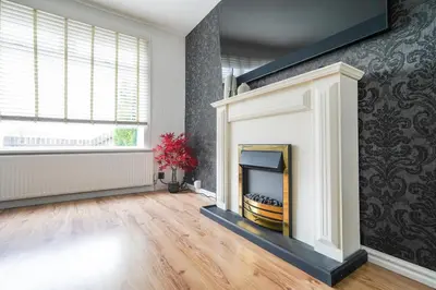 a living room with a fireplace and a window at Livingston 4 Bed + Car Space in Livingston