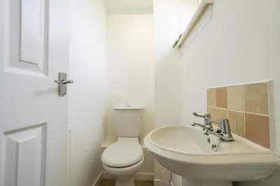 a white bathroom with a toilet and a sink at Livingston 4 Bed + Car Space in Livingston