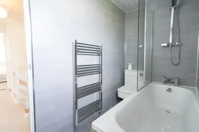 a white bathroom with a tub and a toilet at Livingston 4 Bed + Car Space in Livingston