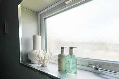 a window with two bottles on a window sill at Livingston 4 Bed + Car Space in Livingston