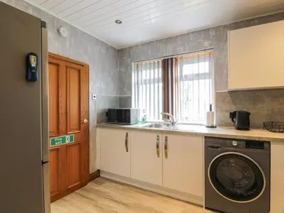 a kitchen with a sink and a washing machine at Largieholm in Mauchline