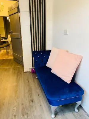 a blue couch with a pink pillow on it at Golfers lovers! Near all famous golf courses in Prestwick