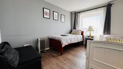 a bedroom with a bed and a chair and a window at Top Floor of the building, spectacular views! in Glasgow