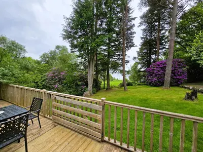 a wooden deck with a table and a bench on it at Ard Veich Estate - Panoramic Highland Sea Views with private beach and woodland in Port Appin