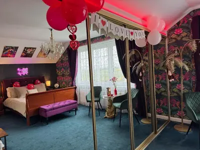 a bedroom with a bed and a table and a mirror at FINN VILLAGE - Loch Lomond Villa - THE JUNGLE ROOM with a PRIVATE HOT TUB in Drymen