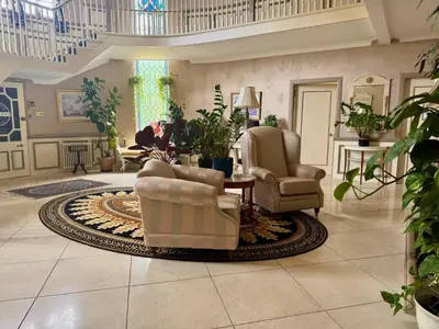 a living room with two chairs and a rug at FINN VILLAGE - Loch Lomond Villa - THE JUNGLE ROOM with a PRIVATE HOT TUB in Drymen