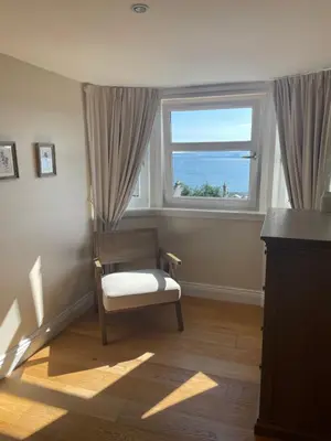a living room with a chair and a window at Inverbeg Cottage in Rothesay