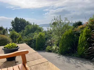 a wooden bench sitting on top of a patio at Inverbeg Cottage in Rothesay