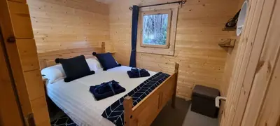 a bedroom with a bed in a log cabin at 2 bed Lodge near Dunoon on the Shore Front in Dunoon