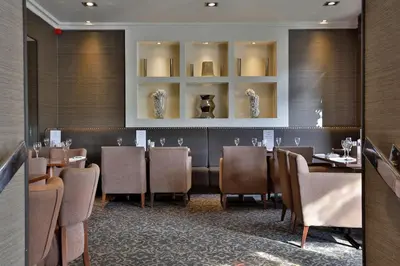 a dining room with tables and chairs in a restaurant at Best Western Motherwell Centre Moorings Hotel in Motherwell