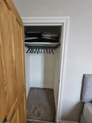 a room with a closet with a door and a shelf at Glebe Apartment in Campbeltown