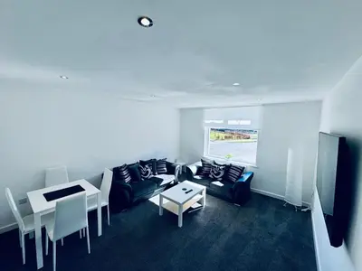 a living room with a couch and a table at Modern 2 bedroom House With Loft Conversion in Glasgow