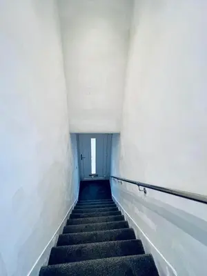 a long staircase in an empty building with a window at Modern 2 bedroom House With Loft Conversion in Glasgow