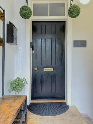 a black door with a rug in front of it at St Johns Jailhouse by the Castle in Stirling