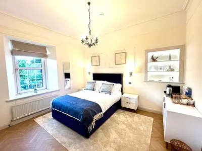 a bedroom with a bed and a chandelier at 9 Bedroom all Ensuite- Exclusive Use in Auchterarder