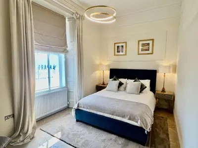 a bedroom with a large bed and a window at 9 Bedroom all Ensuite- Exclusive Use in Auchterarder