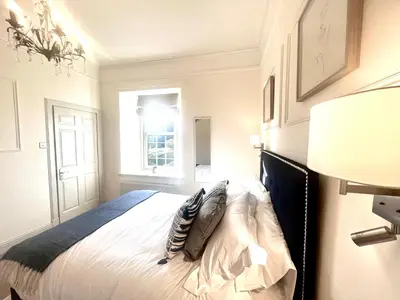 a bedroom with a white bed with a window at 'Hamish' in ApartNest Auchterarder in Auchterarder