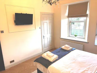 a bedroom with a bed and a tv on the wall at 'Hamish' in ApartNest Auchterarder in Auchterarder