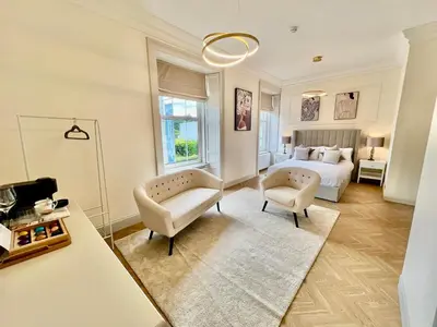 a bedroom with a bed and a couch and chairs at 'Flora' in ApartNest Auchterarder in Auchterarder