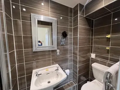 a bathroom with a sink and a toilet and a mirror at 'Flora' in ApartNest Auchterarder in Auchterarder