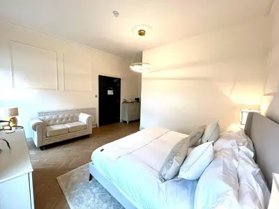 a bedroom with a white bed and a couch at 'Blair' in ApartNest Auchterarder in Auchterarder