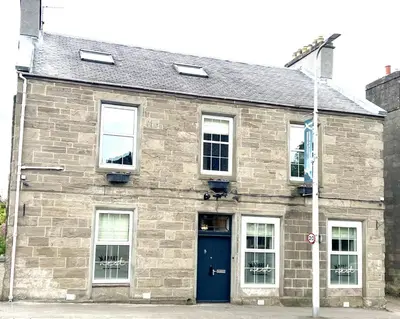 a brick building with a blue door and windows at 'Blair' in ApartNest Auchterarder in Auchterarder