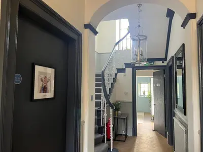 a hallway with a black door and stairs at 'Gordon' in ApartNest Auchterarder in Auchterarder
