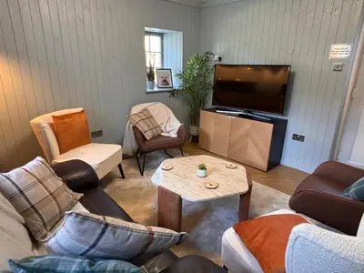 a living room with furniture and a flat screen tv at 'Gordon' in ApartNest Auchterarder in Auchterarder