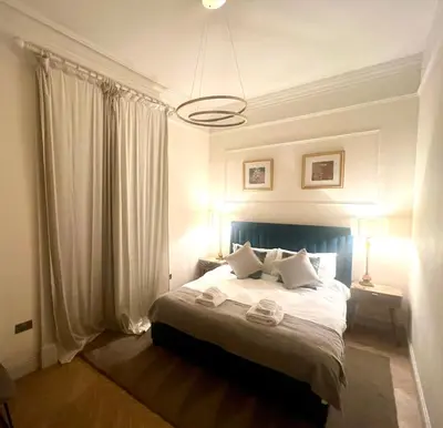 a bedroom with a bed with white sheets and pillows at 'Gordon' in ApartNest Auchterarder in Auchterarder