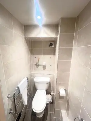 a small bathroom with a toilet and a blue light at 'Douglas' in ApartNest Auchterarder in Auchterarder