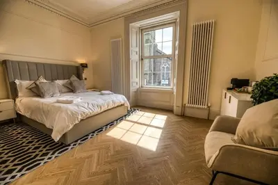 a bedroom with a bed and a couch and a window at 'Douglas' in ApartNest Auchterarder in Auchterarder