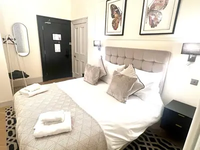 a bedroom with a white bed with two towels on it at 'Douglas' in ApartNest Auchterarder in Auchterarder
