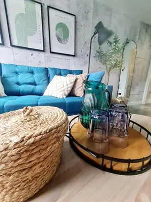 a living room with a blue couch and a table with glasses at Lovely house with back garden - PRIVATE driveway in Glasgow