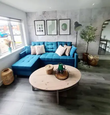 a living room with a blue couch and a table at Lovely house with back garden - PRIVATE driveway in Glasgow