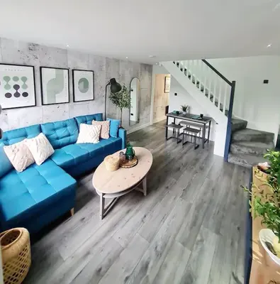 a living room with a blue couch and a table at Lovely house with back garden - PRIVATE driveway in Glasgow
