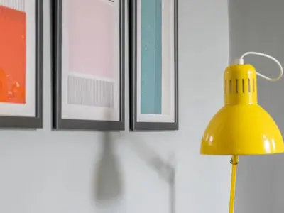 a yellow lamp in front of a wall with pictures at West End Cosy Pop of Colour - Pass the Keys in Glasgow
