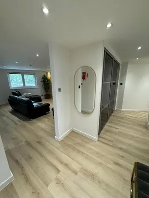 a living room with a black couch and a mirror at KM Granton Apartment in Edinburgh