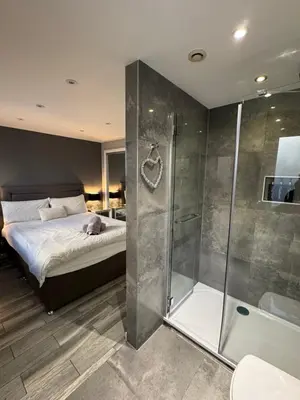 a bedroom with a bed and a glass shower at KM Granton Apartment in Edinburgh