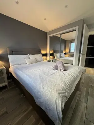 a bedroom with a large bed and a large mirror at KM Granton Apartment in Edinburgh
