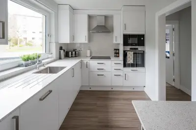 a white kitchen with white cabinets and a sink at Quiet 2 bedroom gem in Stirling in Bridge of Allan