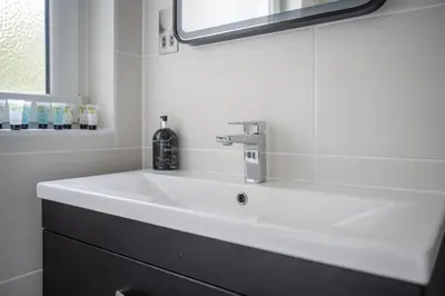a bathroom with a white sink and a mirror at Quiet 2 bedroom gem in Stirling in Bridge of Allan