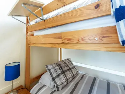 a bunk bed with a blue lamp and a pillow at Carraig Dhubh Cottage - Uk47123 in Whiting Bay