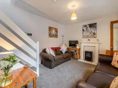 a living room with two couches and a fireplace at Carraig Dhubh North - Uk47125 in Whiting Bay
