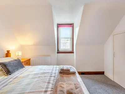 a bedroom with a bed and a window at Carraig Dhubh North - Uk47125 in Whiting Bay