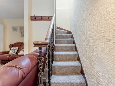 a staircase in a home with a leather couch at Carraig-Dhubh South - Uk47124 in Whiting Bay