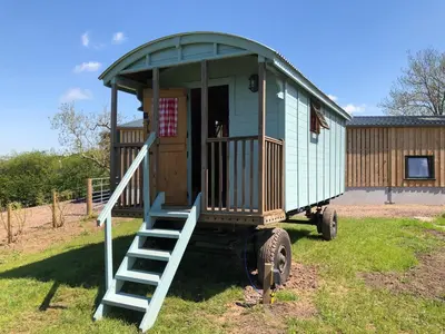 a tiny house with a staircase in a yard at The Bothy and Wagon at Pitmeadow Farm in Perth
